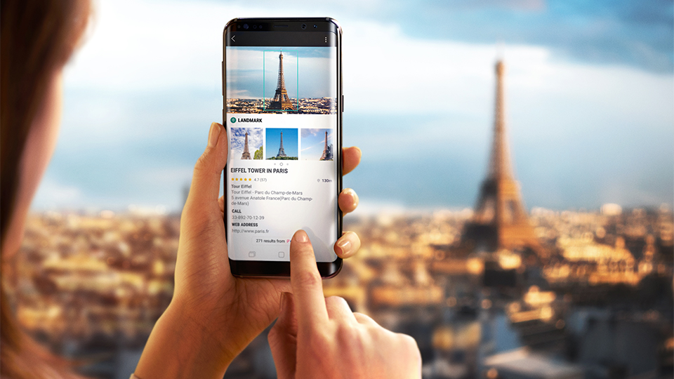 someone using Bixby on their smartphone's camera to view and get info on the Eiffel Tower