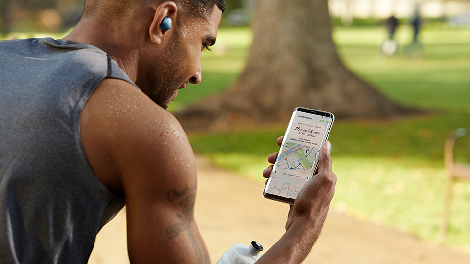 man checking his running route on a Samsung smartphone during his jog