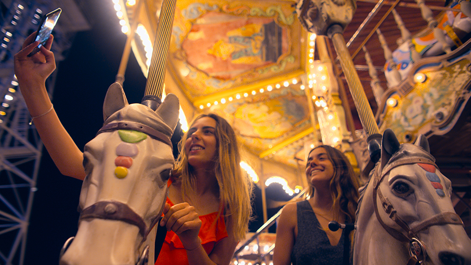 two girls taking a selfie on a carousel