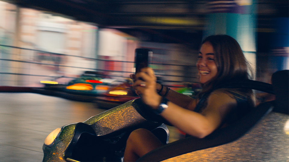 a girl taking a selfie while riding a bumper car