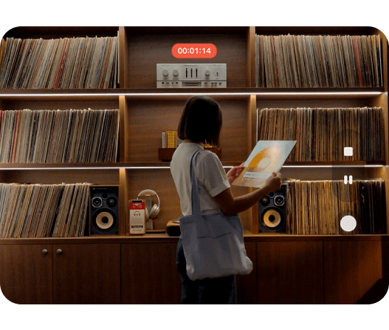 A woman standing in front of a shelving unit filled with vinyls and speakers, with a recording icons overlay. 