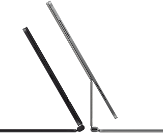 2 iPad Pro devices attached to Magic Keyboard, side exterior, thin profile, space black colour with speakers and USB-C port, tilted half open, silver colour, open, tilted back showing the keyboard’s floating cantilever design, speakers and microphone