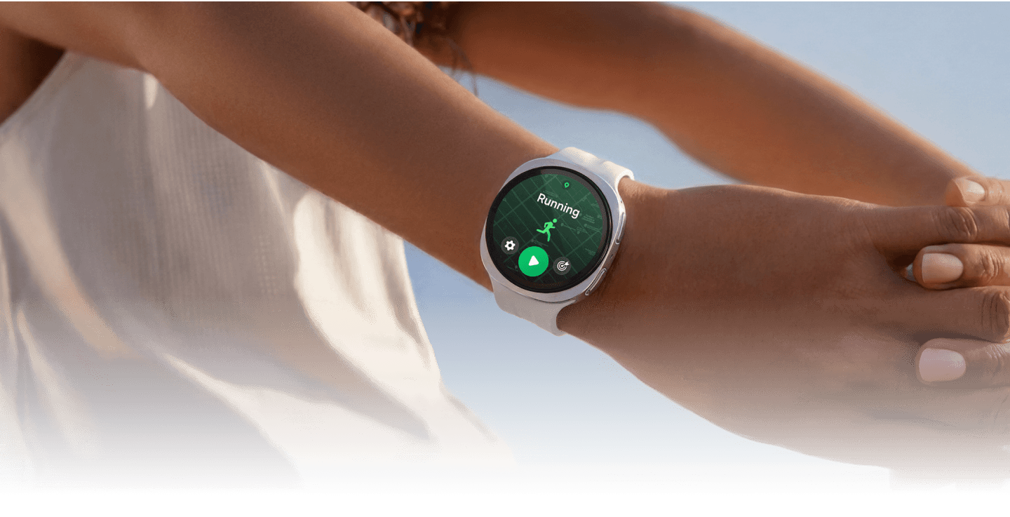 A picture of a woman with her arms stretched behind her wearing the Watch9 showing running in progress