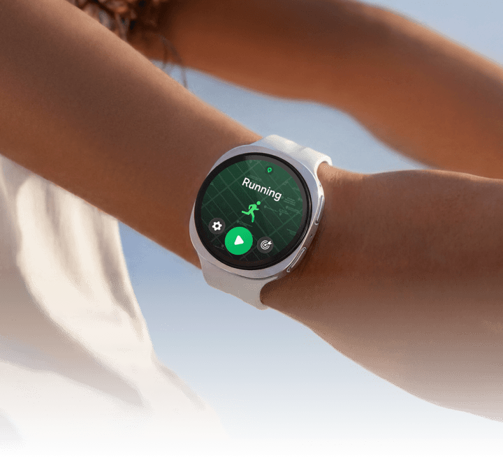 A picture of a woman with her arms stretched behind her wearing the Watch9 showing running in progress