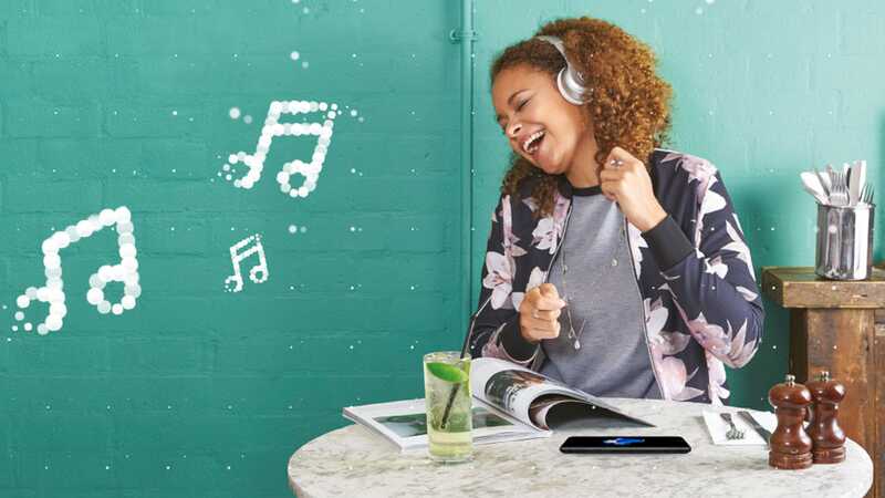 Young woman listening to music on her headphones and singing along