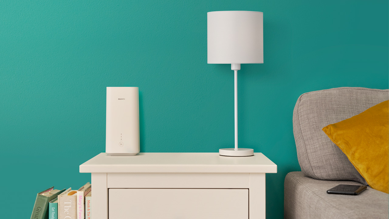  The 5GEE WiFi Home Router sitting on a table next to a lamp in a living room setting 