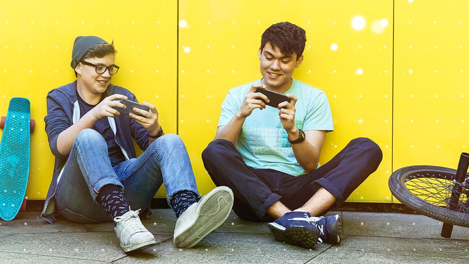 Two people sitting on and playing on their mobile devices