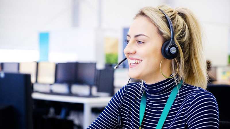 Call Centre worker wearing a headset and speaking to a customer