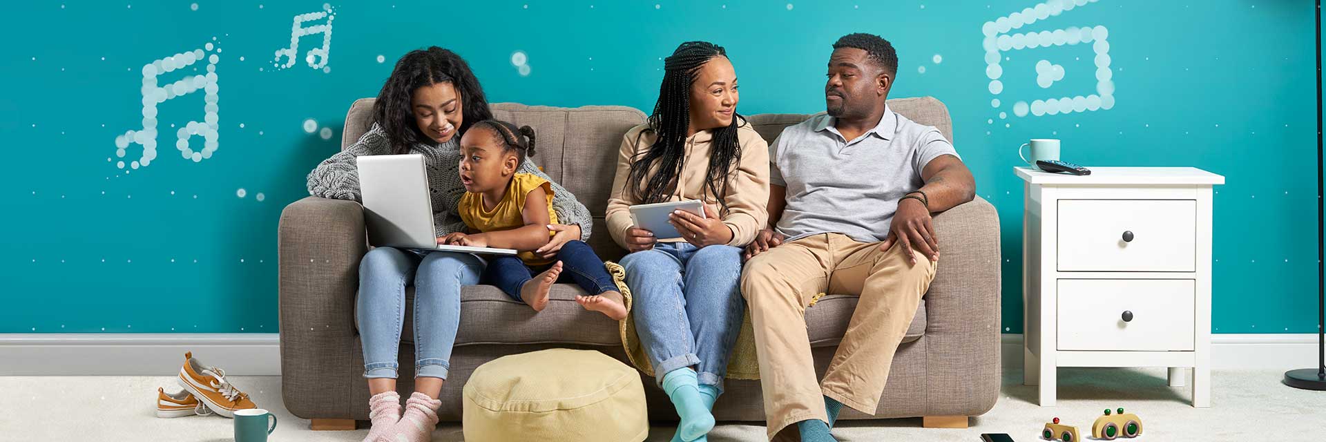 Family sitting on a couch playing with a laptop