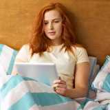 Woman on a tablet in bed
