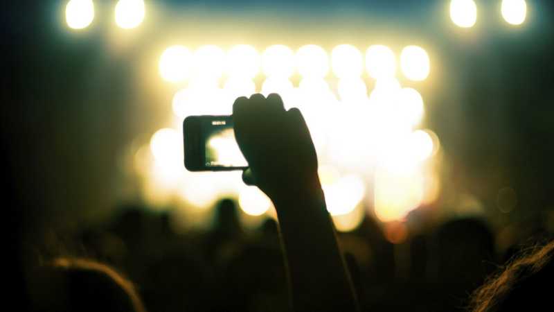 Taking a photo on a smartphone during a concert