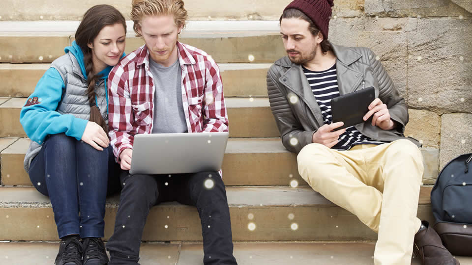 Students gathering around a laptop