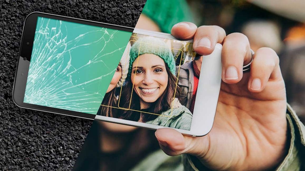 Woman holding a mobile phone with half a smashed screen