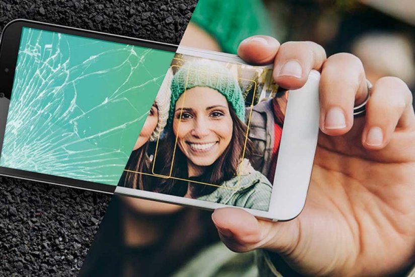 Woman holding a mobile phone with half a smashed screen