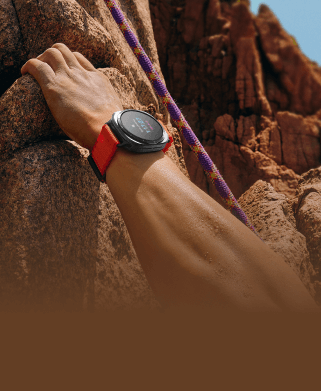 a hand holding a rock as climbs wearing the watch