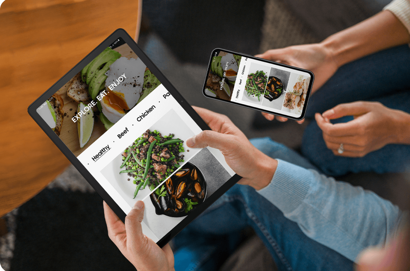 2 people holding their devices exploring new food recipes.