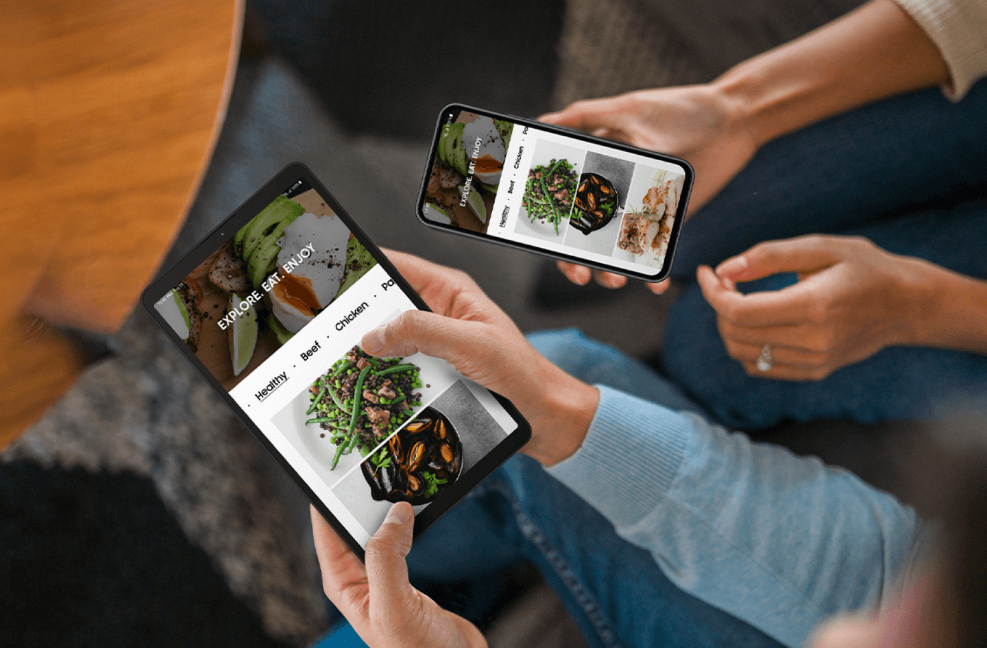 2 people holding their devices exploring new food recipes.