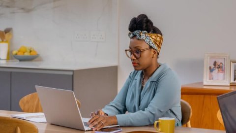 Woman sat with laptop at kitchen table