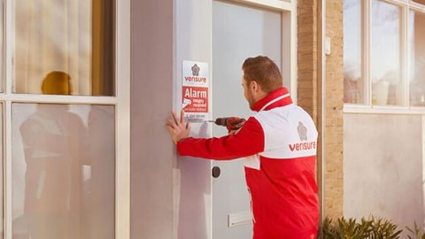 Man in red and white jacket putting up Verisure sign