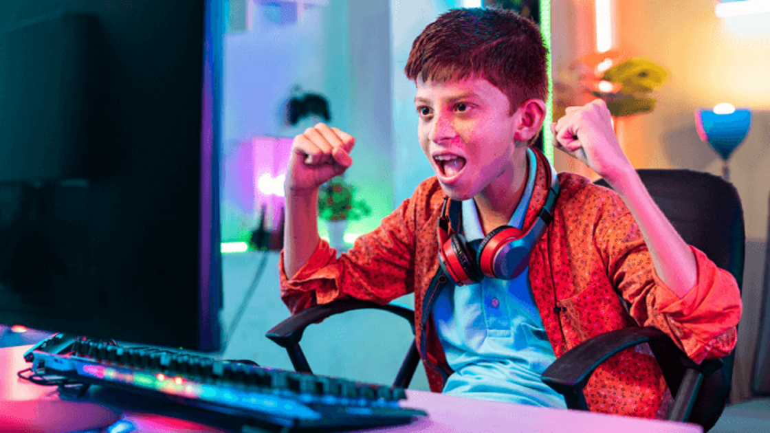 A boy celebrating while playing video games