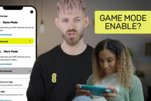 Man with woman whilst she plays on a video console