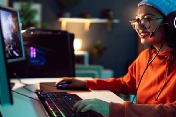 Young girl with glasses wearing headphones playing a PC video game